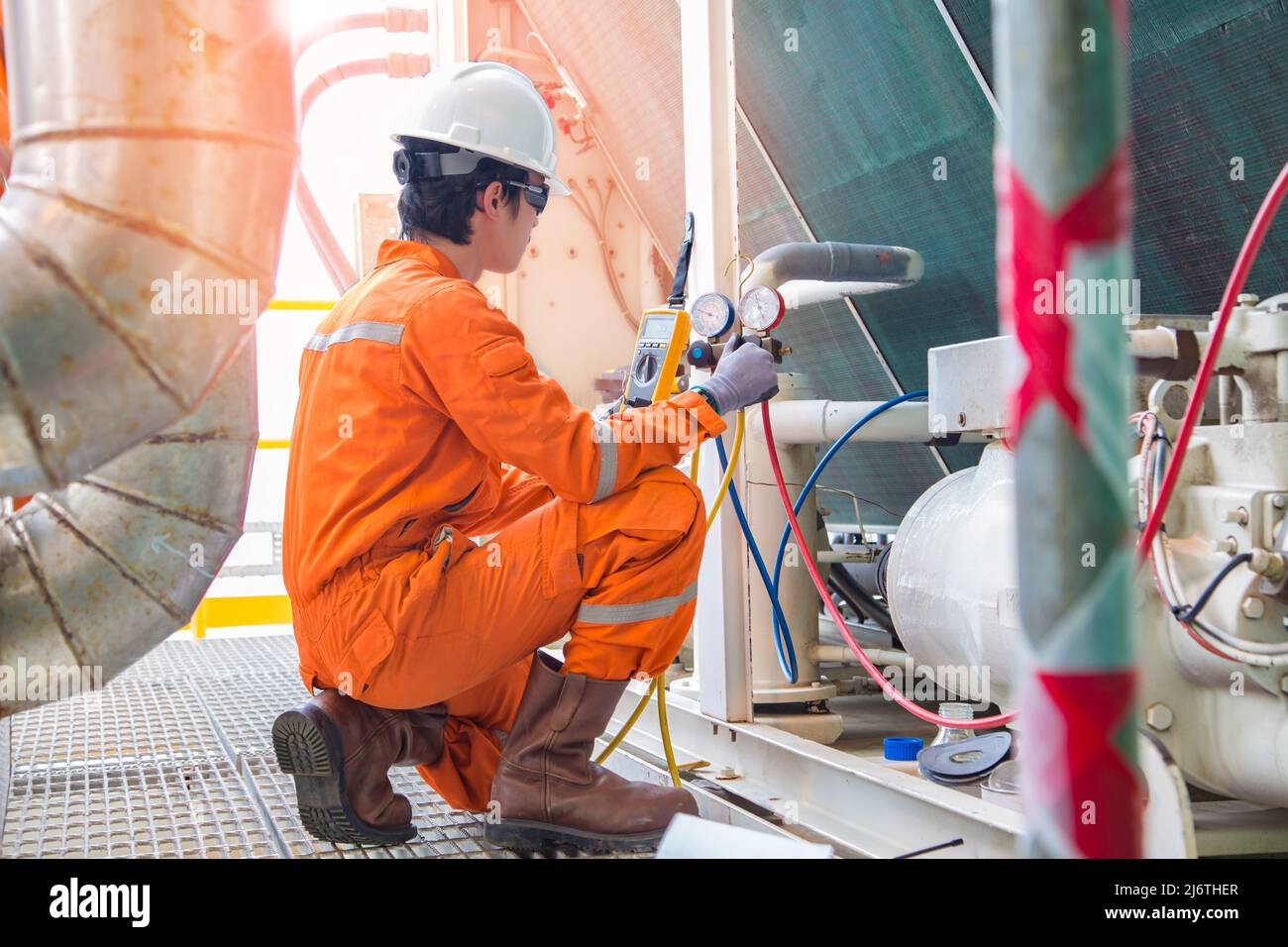 Un électricien inspecte et vérifie le chauffage ventilé et la climatisation (HVAC), le service de climatisation dans la plate-forme de forage pétrolier offshore pendant Banque D'Images