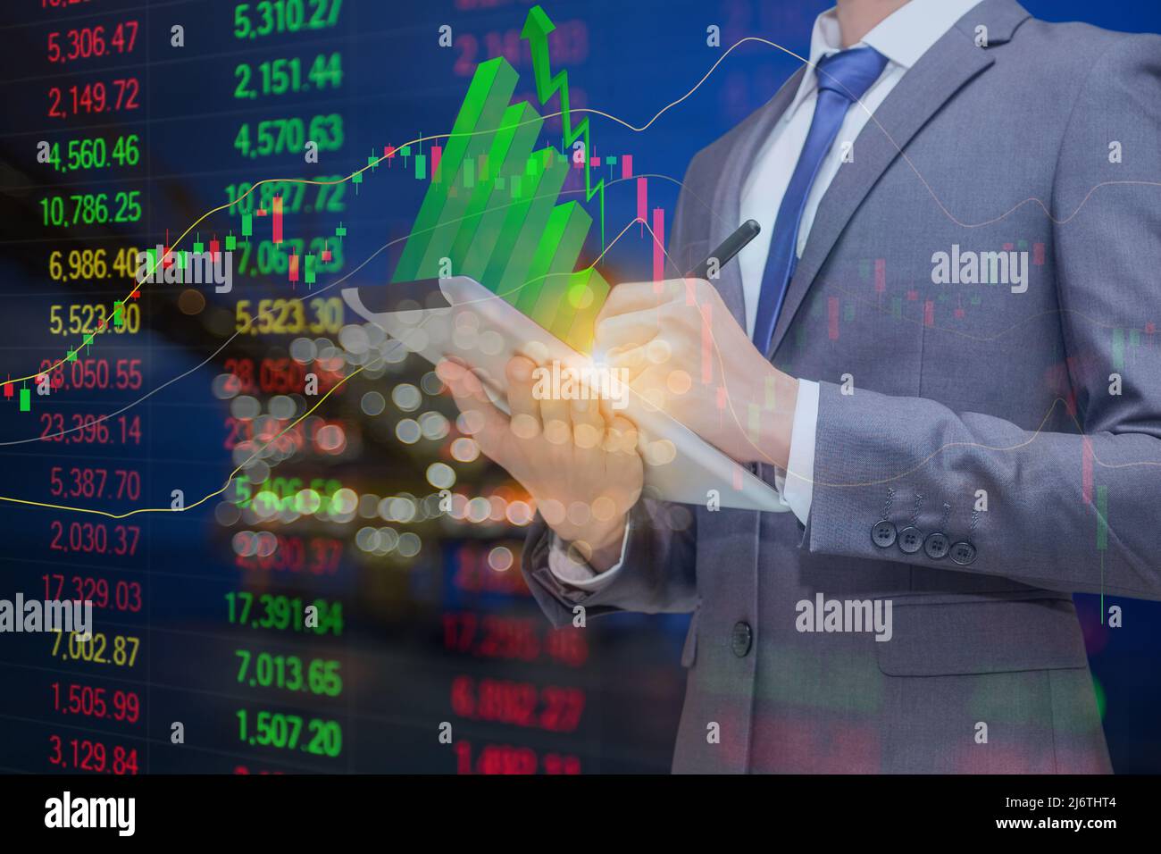 Homme d'affaires tenant une tablette avec un graphique à bâton vert sur le dessus et le fond est la plate-forme de traitement du pétrole et du gaz et le graphique d'indice de stock avec indicateur, le pétrole Banque D'Images