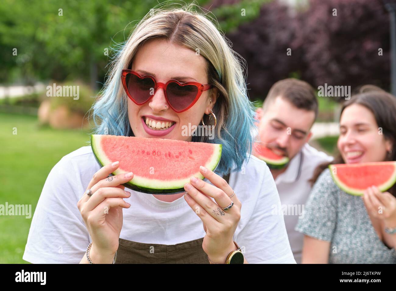 Bonne jeune femme souriante tenant un morceau de pastèque. Banque D'Images