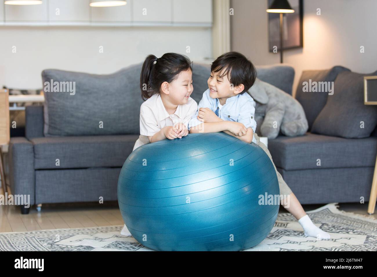 Un garçon et une fille jouant intimement dans le salon de leur maison - photo de stock Banque D'Images