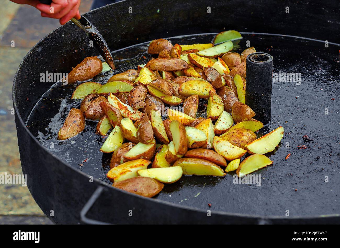 Cuisine de rue. Pommes de terre frites dans une grande casserole. Délicieux repas rapide. Banque D'Images