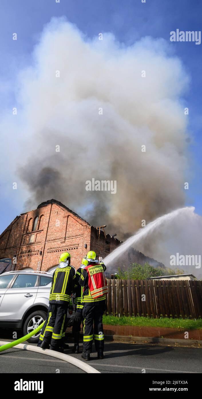 04 mai 2022, Basse-Saxe, Gehrden: Les pompiers éteignent un incendie dans une ferme de la région de Hanovre. Une grange dans laquelle, entre autres choses, une entreprise de construction de stand d'exposition opératait, brûlée au sol le matin. Le nuage de fumée pourrait être vu pendant des kilomètres. Photo: Julian Stratenschulte/dpa Banque D'Images