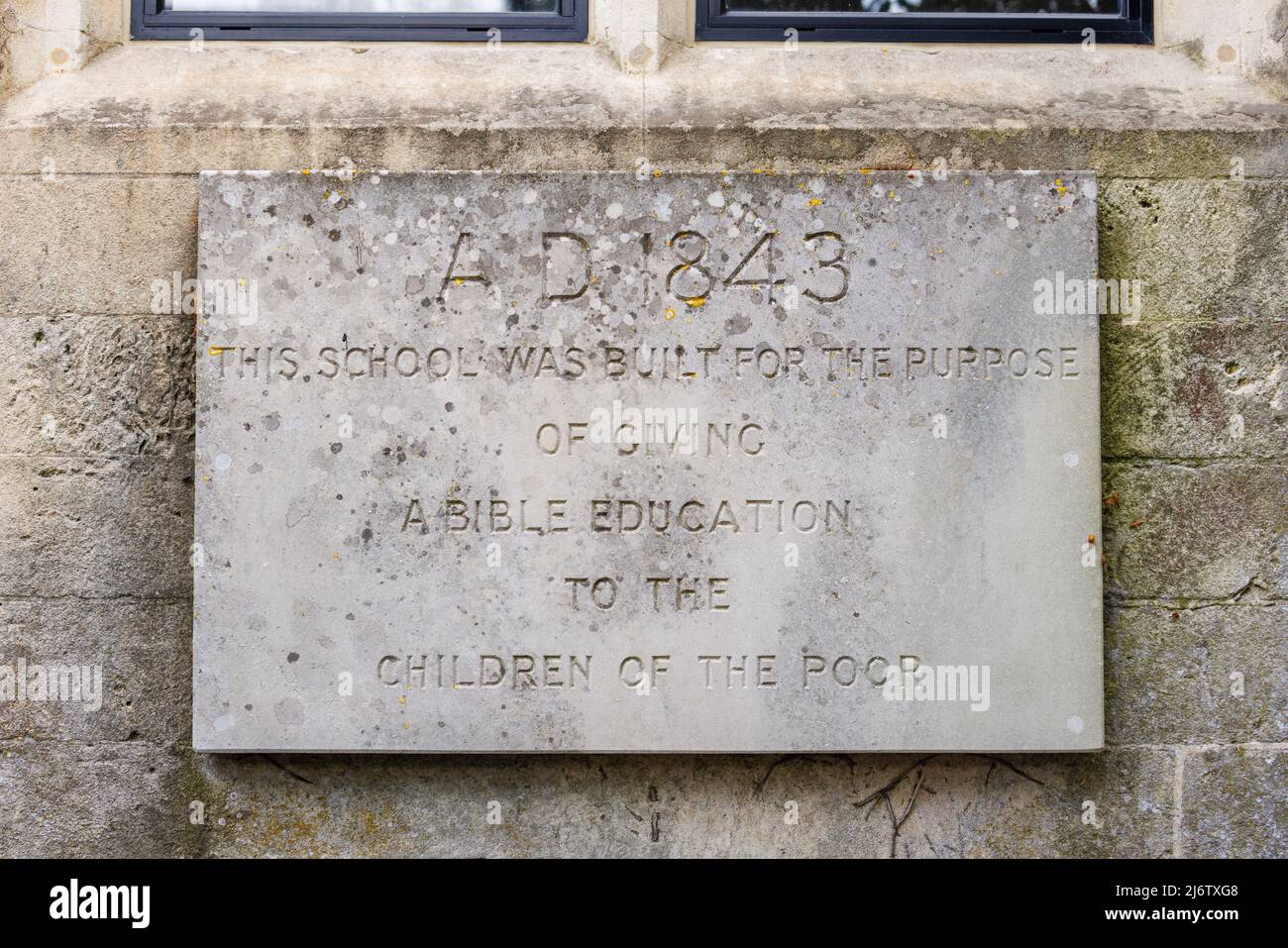 Inscription sur une école religieuse de 19th siècles pour une éducation biblique des pauvres à Shelbourne, un petit village préservé dans la campagne du Wiltshire, en Angleterre Banque D'Images