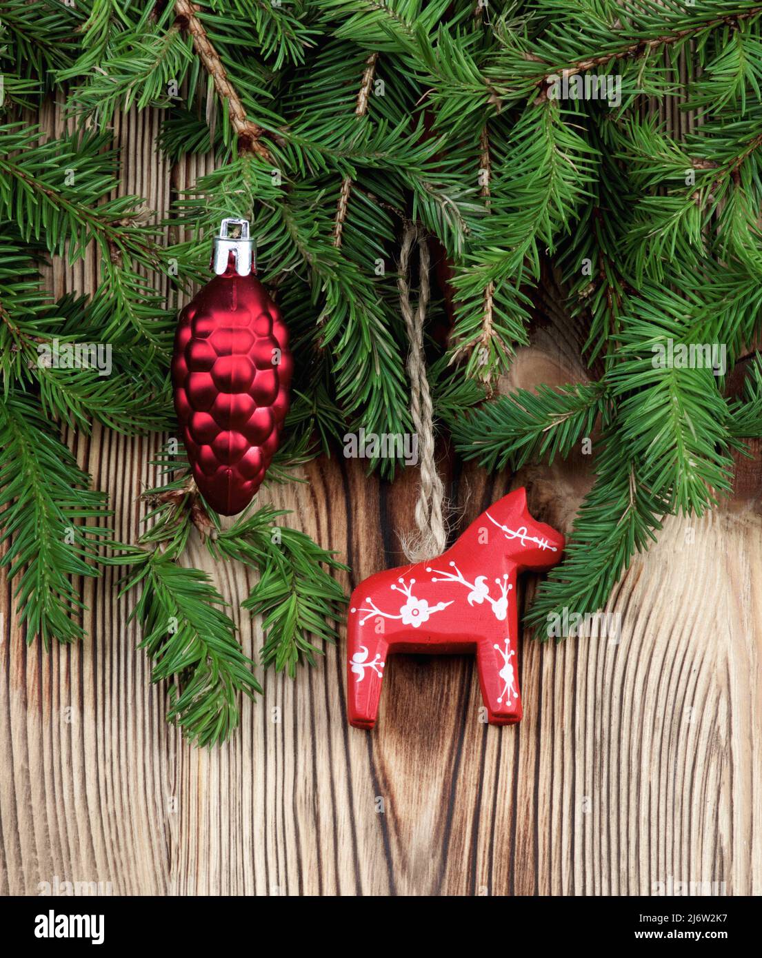 Décoration de Noël avec cône décoratif et cheval rouge entre la branche de l'épinette sur fond en bois Banque D'Images