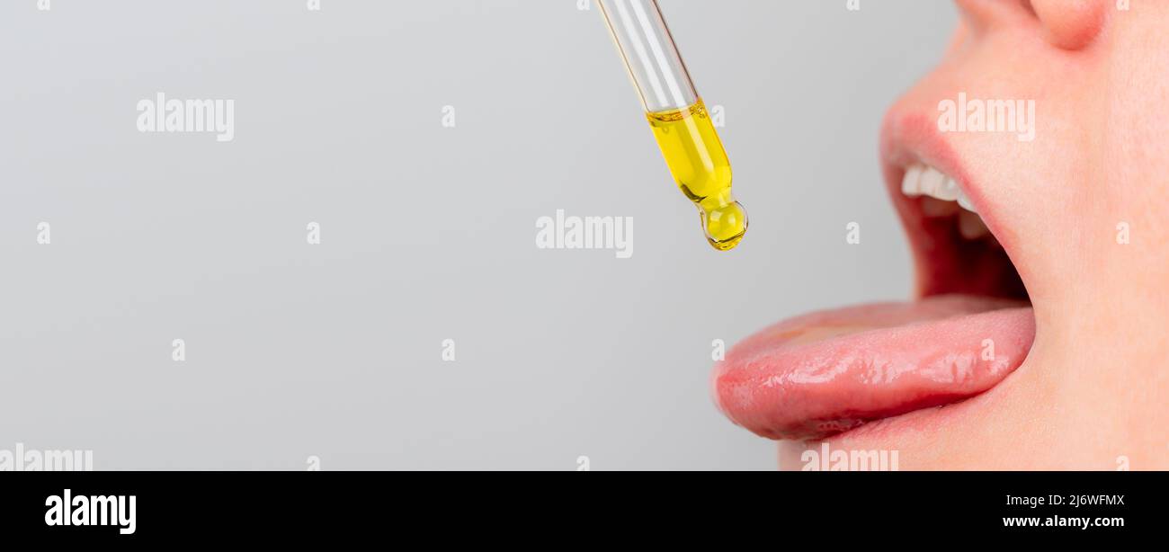 pipette à huile de langue. herbes médecine alternative et compléments alimentaires femme prenant cbd huile de chanvre gouttes dans la bouche de dropper Banque D'Images