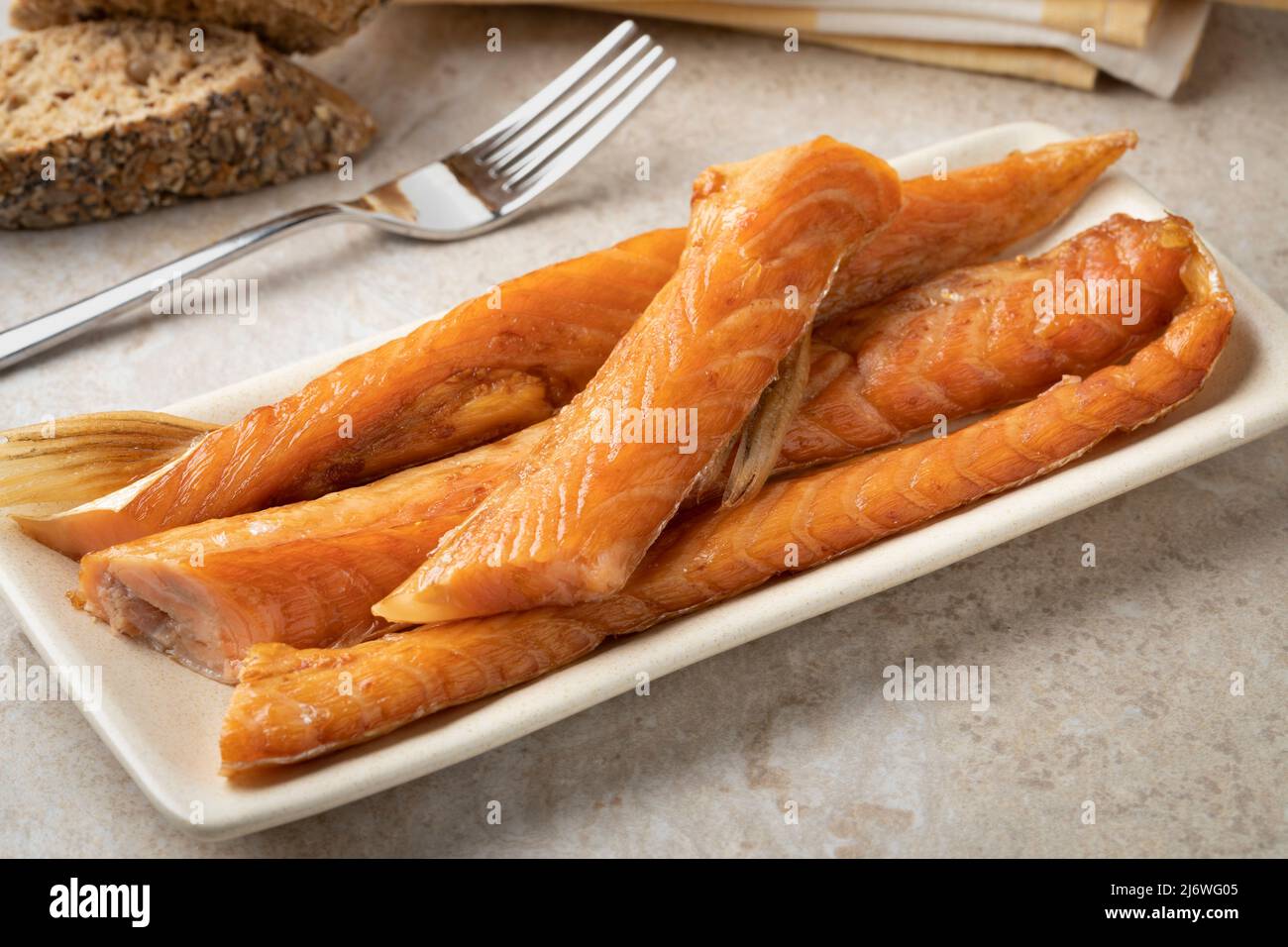 Des bandes de saumon fumé frais sur une assiette en gros plan Banque D'Images