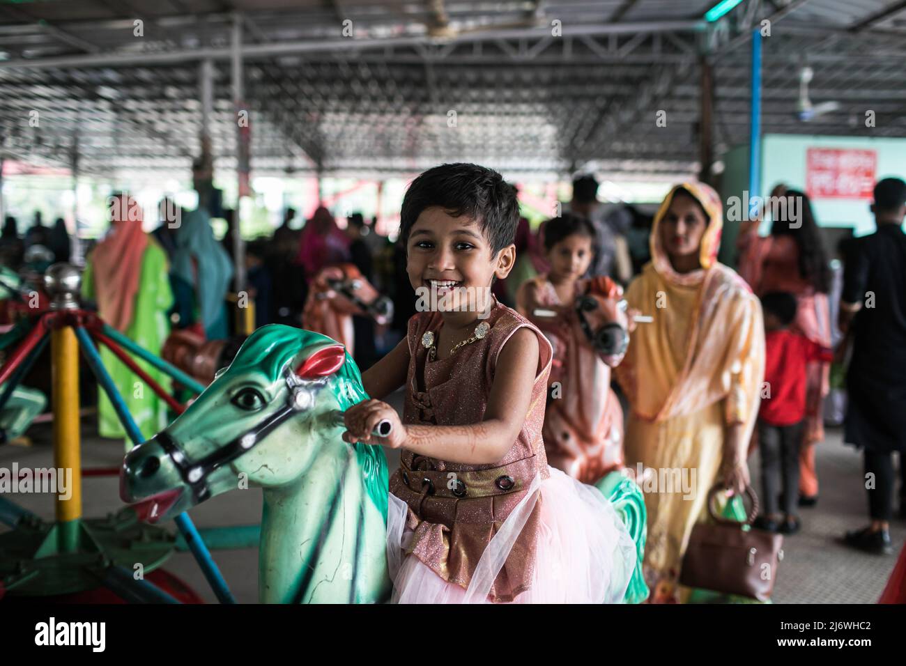 Un enfant vu en train de profiter d'une promenade dans un parc d'attractions pendant les vacances d'Eid. Sans aucune restriction, tous les centres d'amusement ouverts pour accueillir plus de personnes pour la première fois depuis que Covid-19 a frappé le pays, le gouvernement a permis aux lieux touristiques, les centres communautaires et les parcs d'attractions de reprendre les services. Banque D'Images