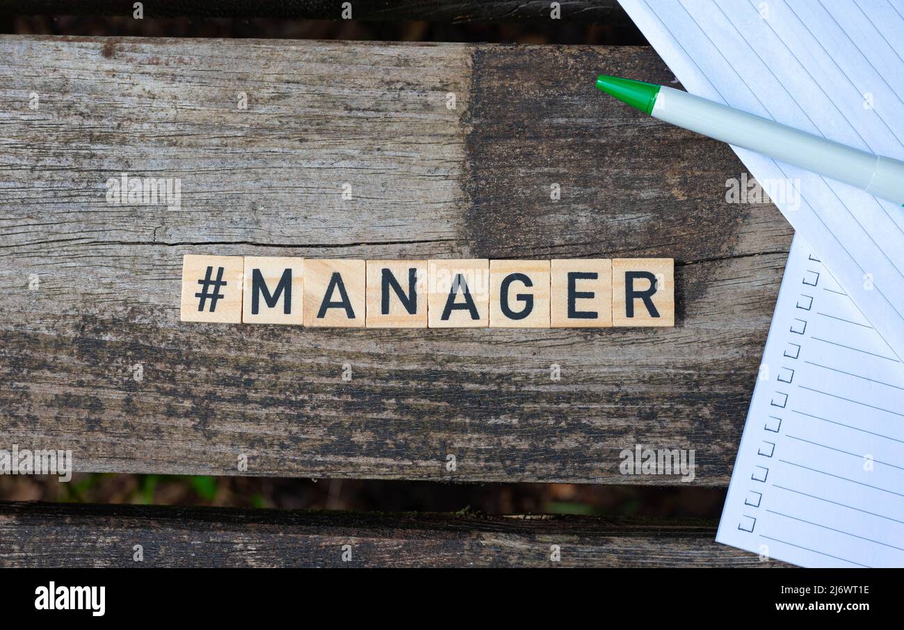 Des blocs de jouets en bois avec le gestionnaire de texte dessus avec le stylo et le papier en arrière-plan. Photo parfaite pour les recruteurs, les RH, les entreprises, les entreprises Banque D'Images