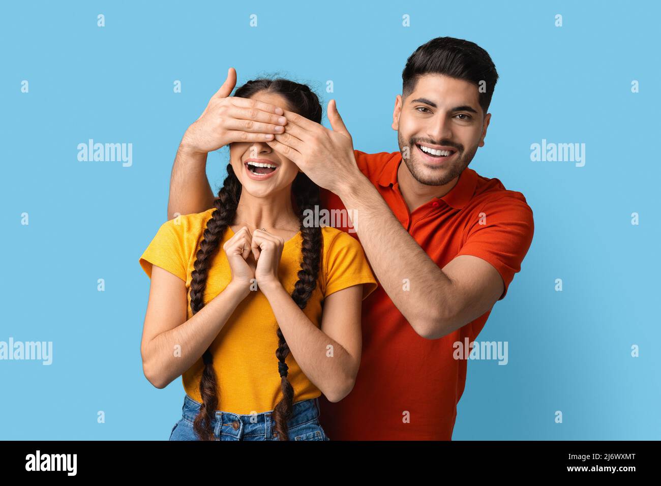 Beau jeune homme arabe couvrant les yeux de la petite amie avec les mains, jouant deviner qui Banque D'Images
