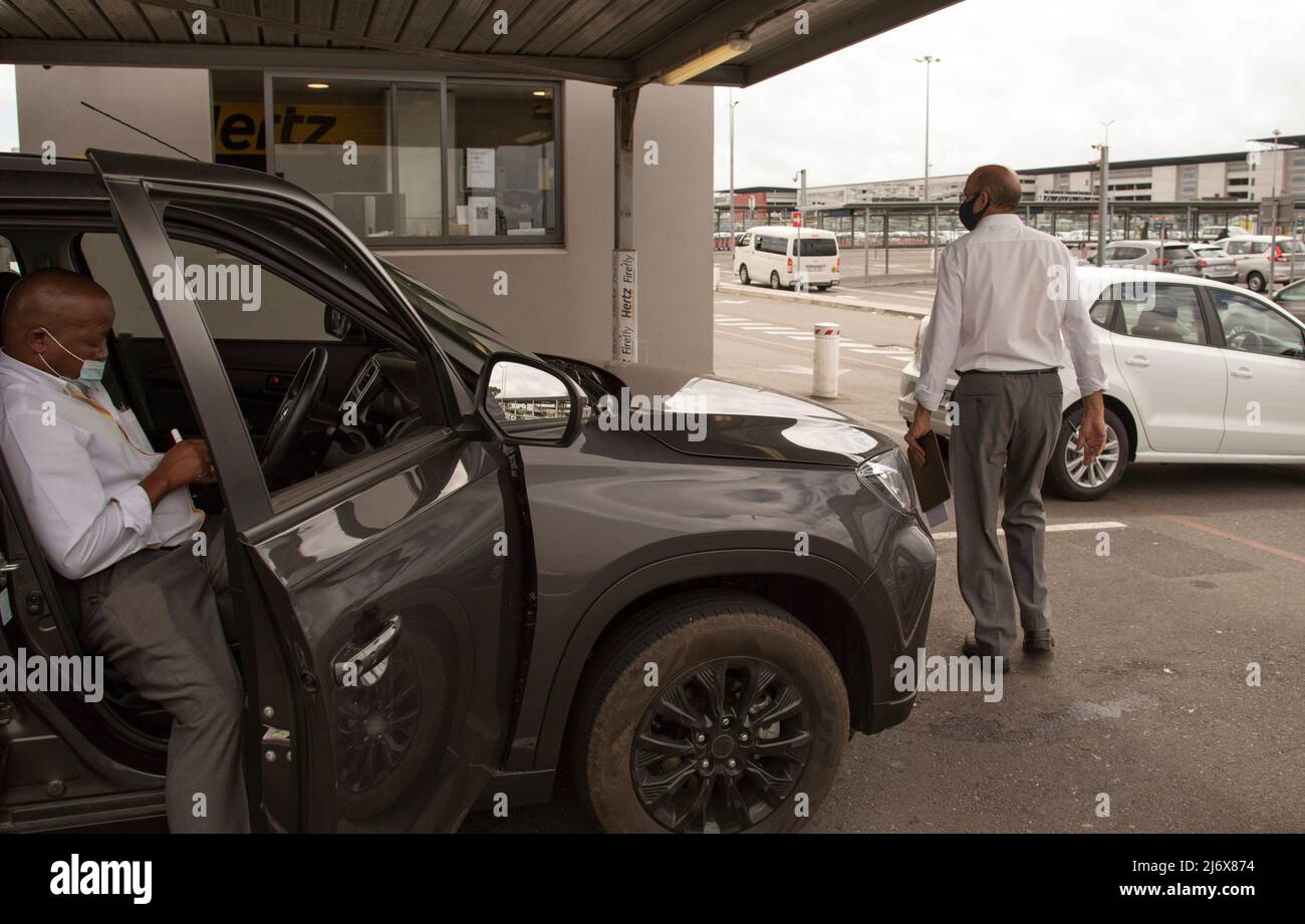 Le Cap, Afrique du Sud. 2022. Location de voiture à l'aéroport renvoie un employé vérifiant une voiture noire qui vient d'être retournée au dépôt. Banque D'Images Le Cap, Afrique du Sud. 2022. Location de voiture à l'aéroport renvoie un employé vérifiant une voiture noire qui vient d'être retournée au dépôt. Banque D'Images