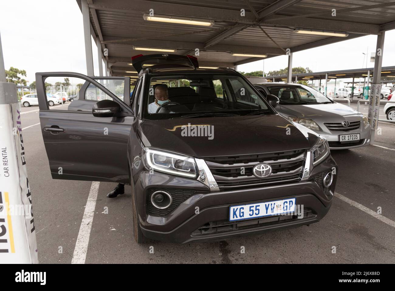 Le Cap, Afrique du Sud. 2022. Location de voiture à l'aéroport renvoie un employé vérifiant une voiture noire qui vient d'être retournée au dépôt. Banque D'Images Le Cap, Afrique du Sud. 2022. Location de voiture à l'aéroport renvoie un employé vérifiant une voiture noire qui vient d'être retournée au dépôt. Banque D'Images