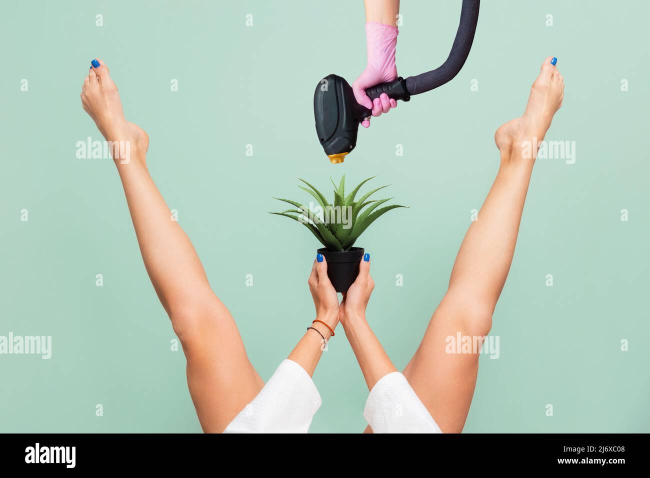 Épilation au laser. Elle leva ses belles jambes à l'écart, tenant une  plante piqueuse entre ses jambes. Main tenant le pistolet laser de  l'équipement médical. Gree Photo Stock - Alamy