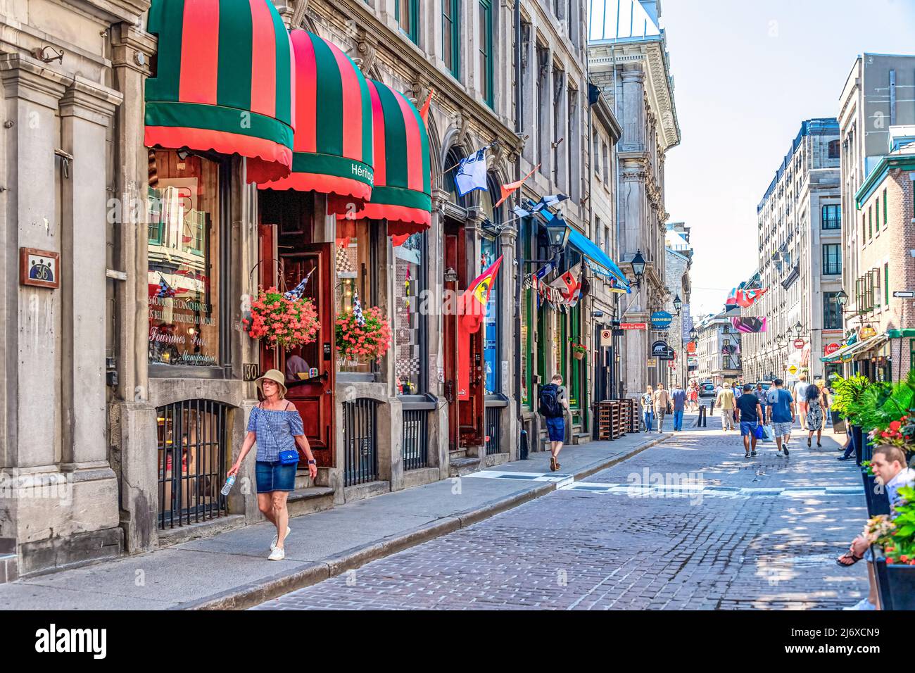 Les touristes marchant dans une rue pavée où se trouvent les petites entreprises. L'architecture de style colonial est située dans le quartier du Vieux-Montréal W Banque D'Images