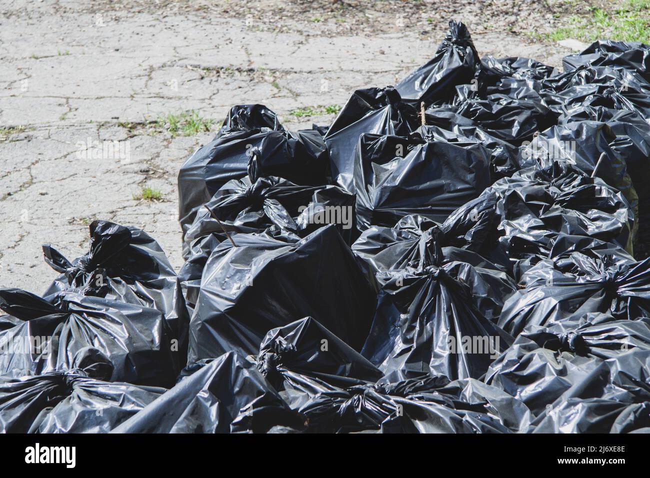 Nettoyage des rues de la ville. Ordures dans des sacs noirs dans les rues de la ville. Recyclage. Banque D'Images