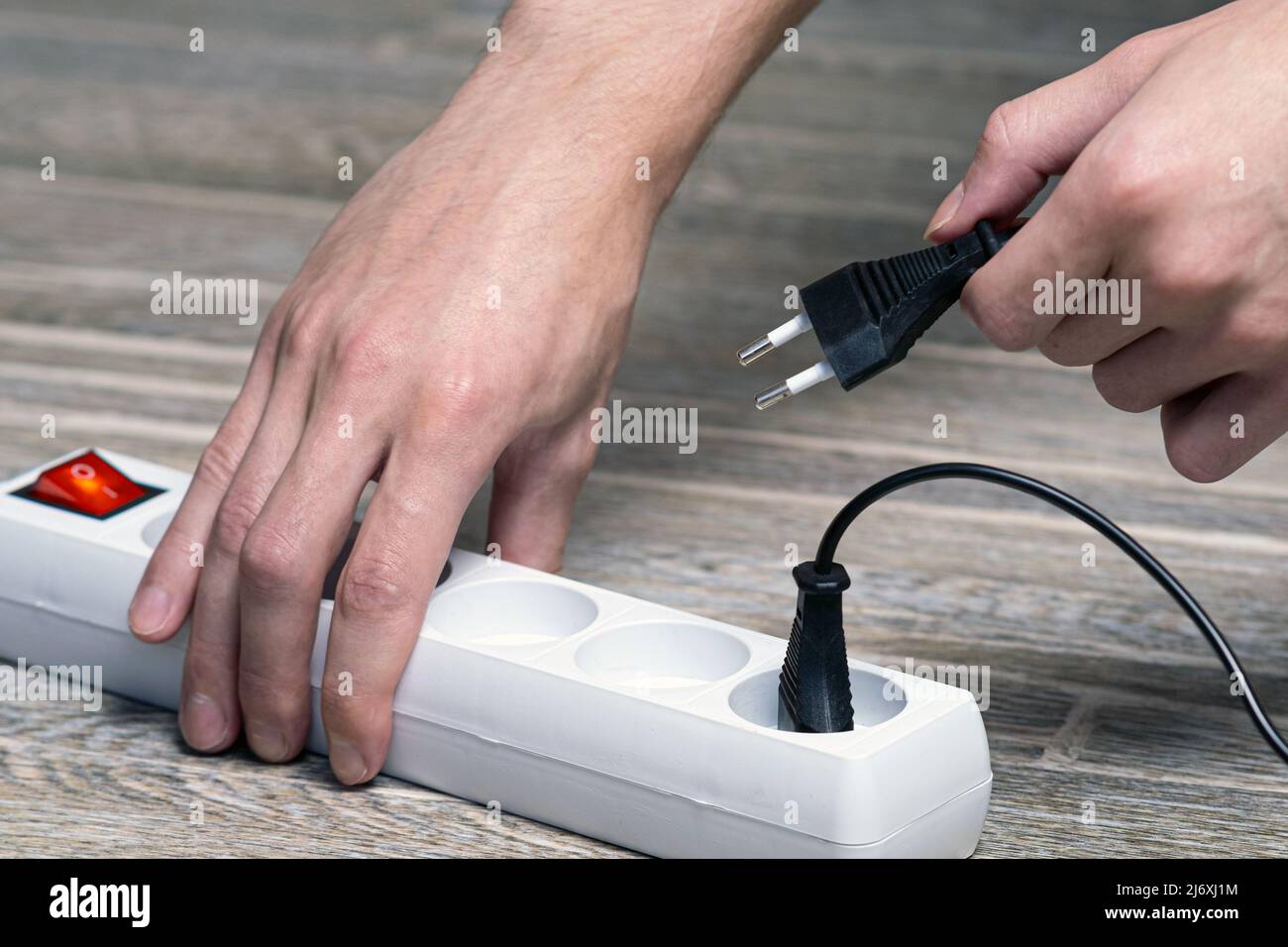Rallonge électrique pour la maison. Insertion manuelle de la fiche dans le cordon d'extension en gros plan. Banque D'Images