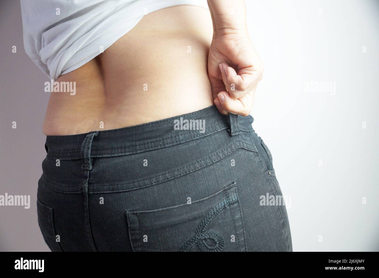 une femme curvaceous tire un jean sur ses fesses en gros plan Banque D'Images
