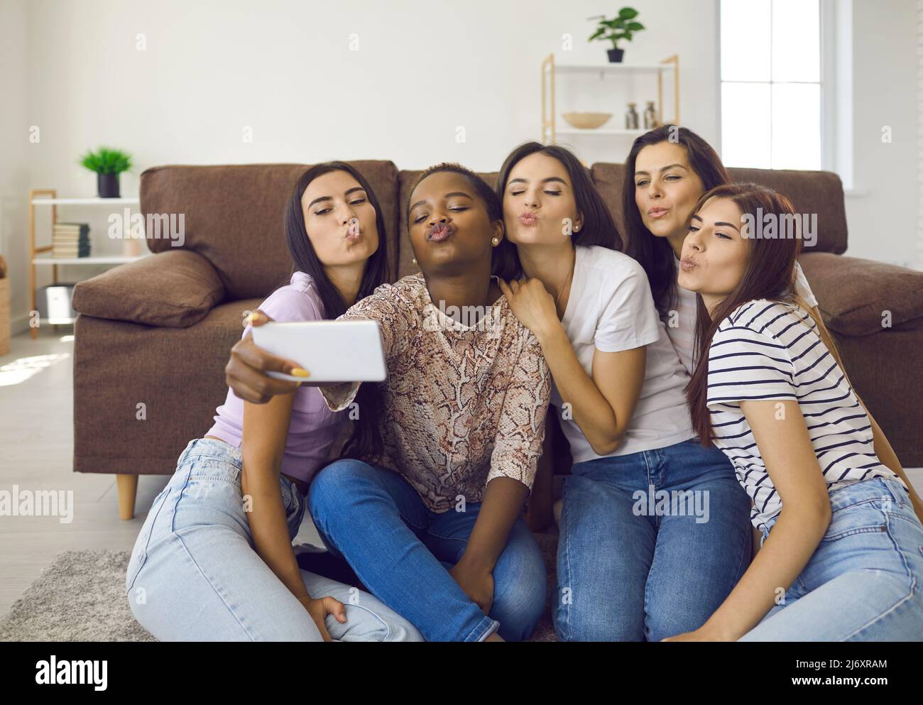 Groupe de jeunes femmes heureux et diverses faisant des visages de canard et prenant selfie sur le téléphone cellulaire Banque D'Images