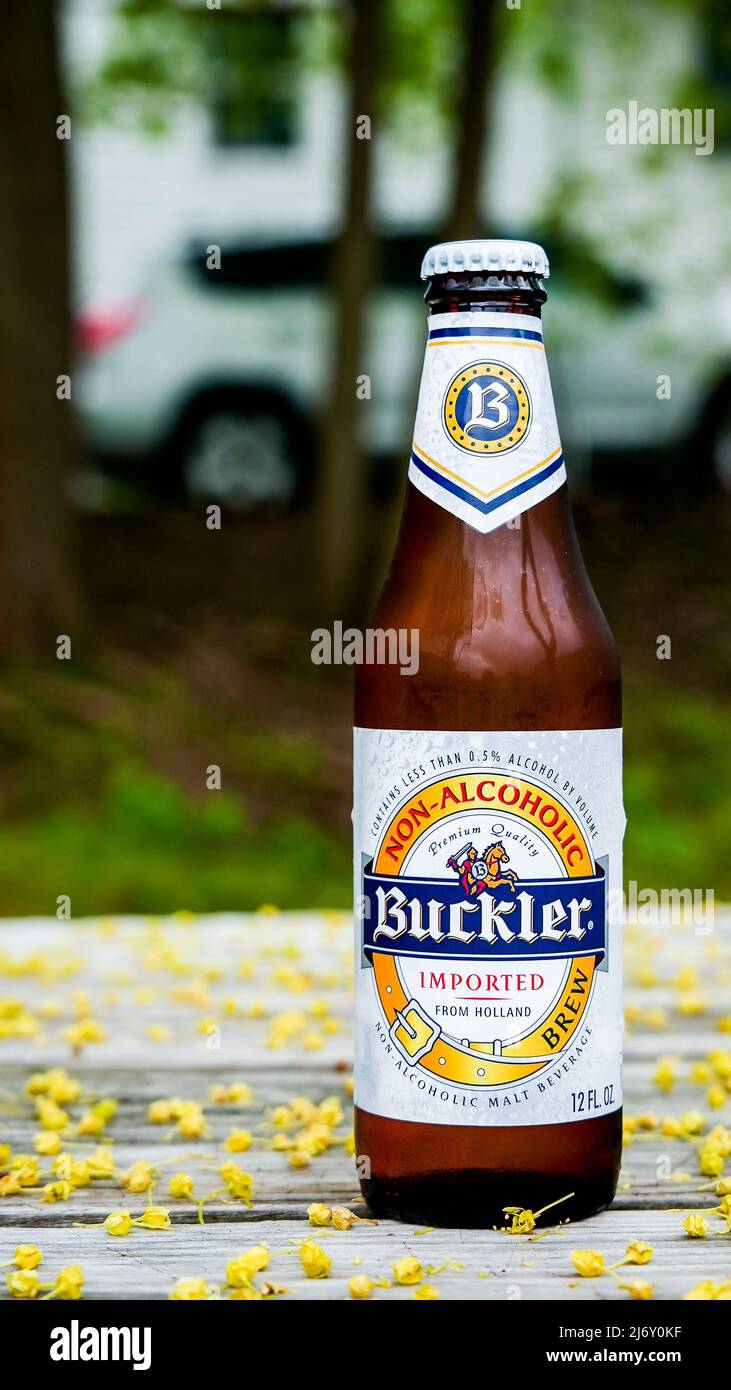 NORWALK, CT, États-Unis - 4 MAI 2022 : bouteille de bière Buckler non alcoolique importée de Hollande sur une table de jardin à l'extérieur couverte par la pollution des arbres au sprin Banque D'Images