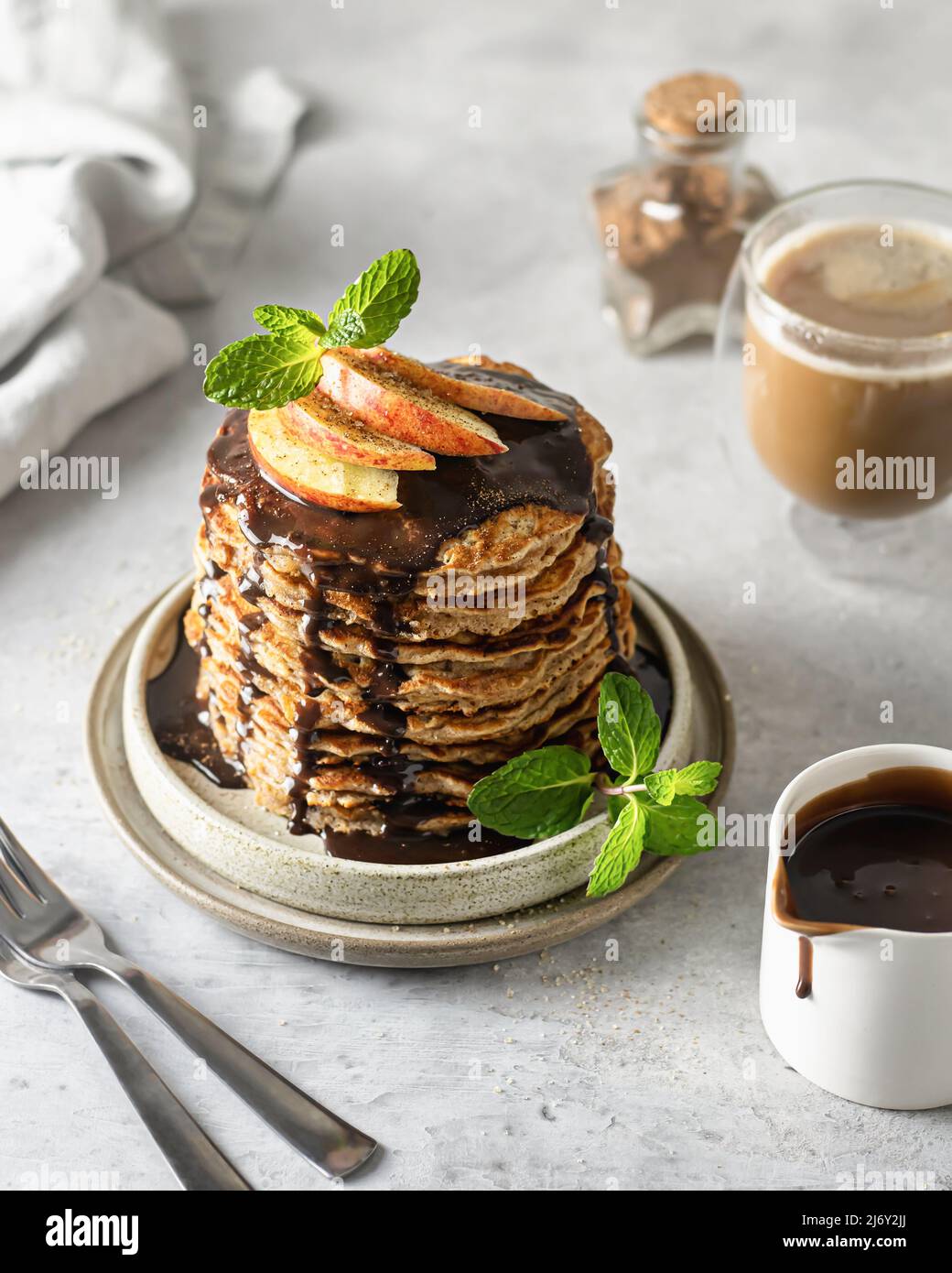 Une pile de crêpes végétariennes à l'avoine pour le petit-déjeuner, décorées de fruits et de menthe Banque D'Images