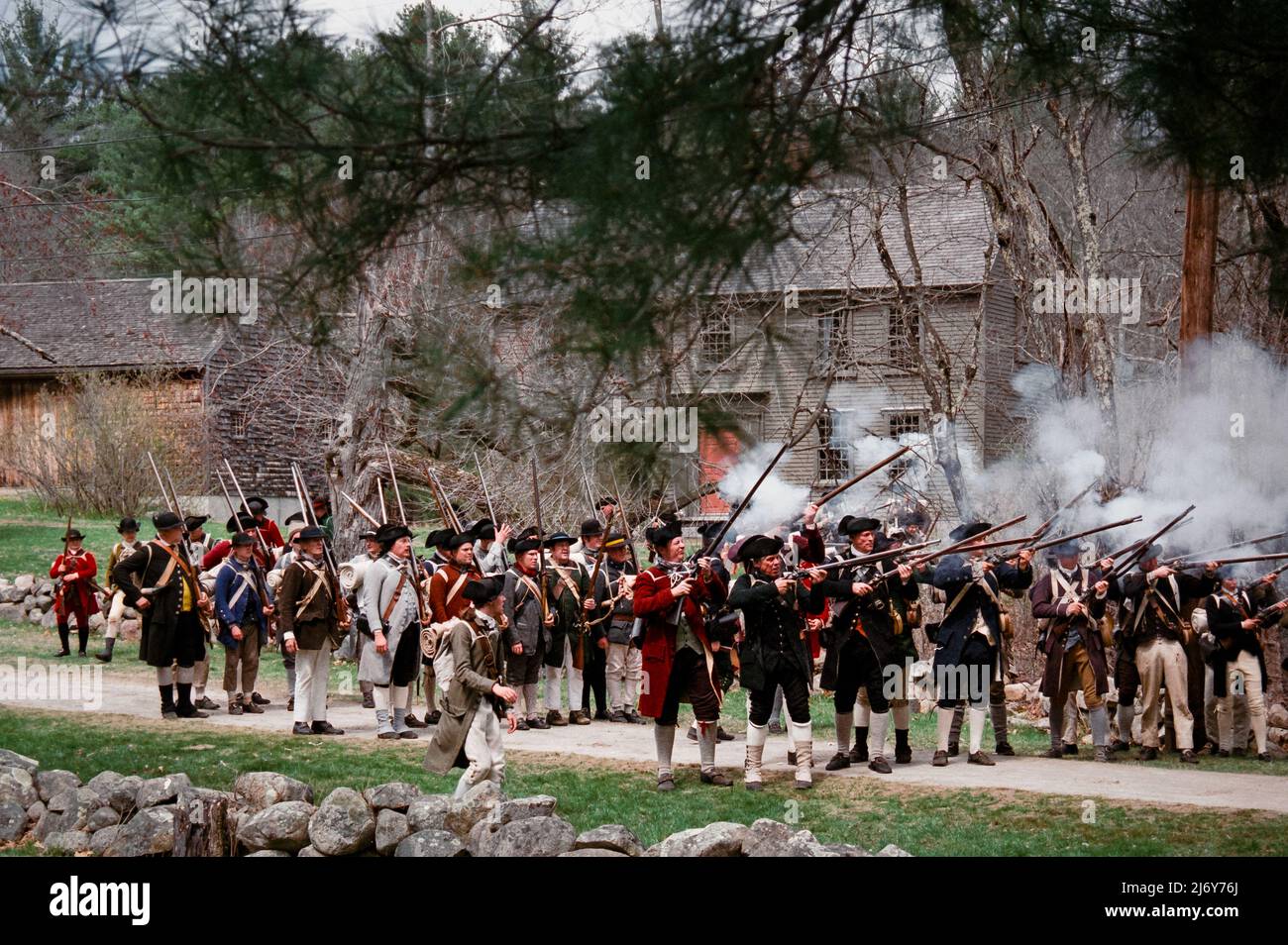 Les personnages de la reconstitution de Minuteman ont eu le feu lors de la reprise des soldats de Redcoat sur Battle Road, devant les troupes de Lexington, Massachusetts, pendant Patriots Da Banque D'Images