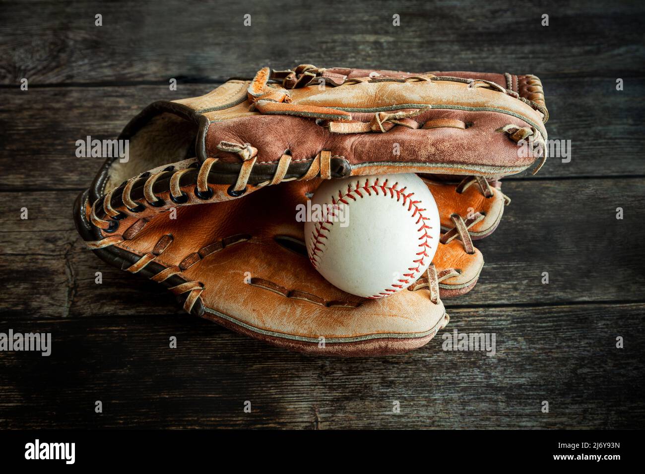 Gant de baseball ou de softball en cuir avec ballon sur fond de bois rustique. Banque D'Images