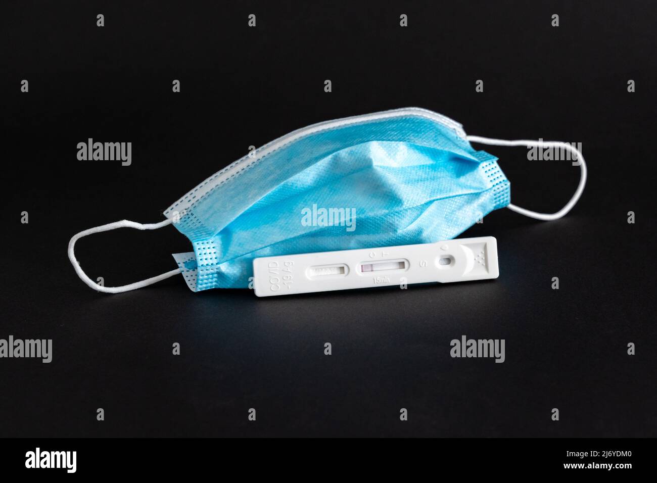 Test de salive de l'antigène Covid-19 avec résultat négatif à côté d'un masque médical. Spécimen en plastique pour un contrôle rapide du coronavirus par Hotgen. Banque D'Images