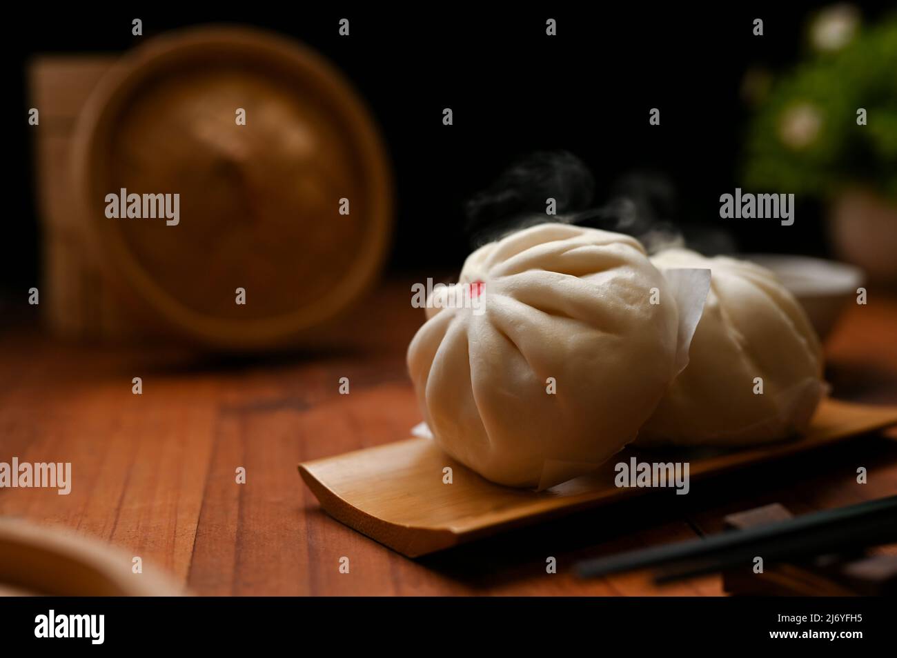 Savoureux de viande chaude ou de petits pains de porc cuits à la vapeur sur une assiette en bois. Concept de cuisine chinoise traditionnelle, en gros plan. Banque D'Images