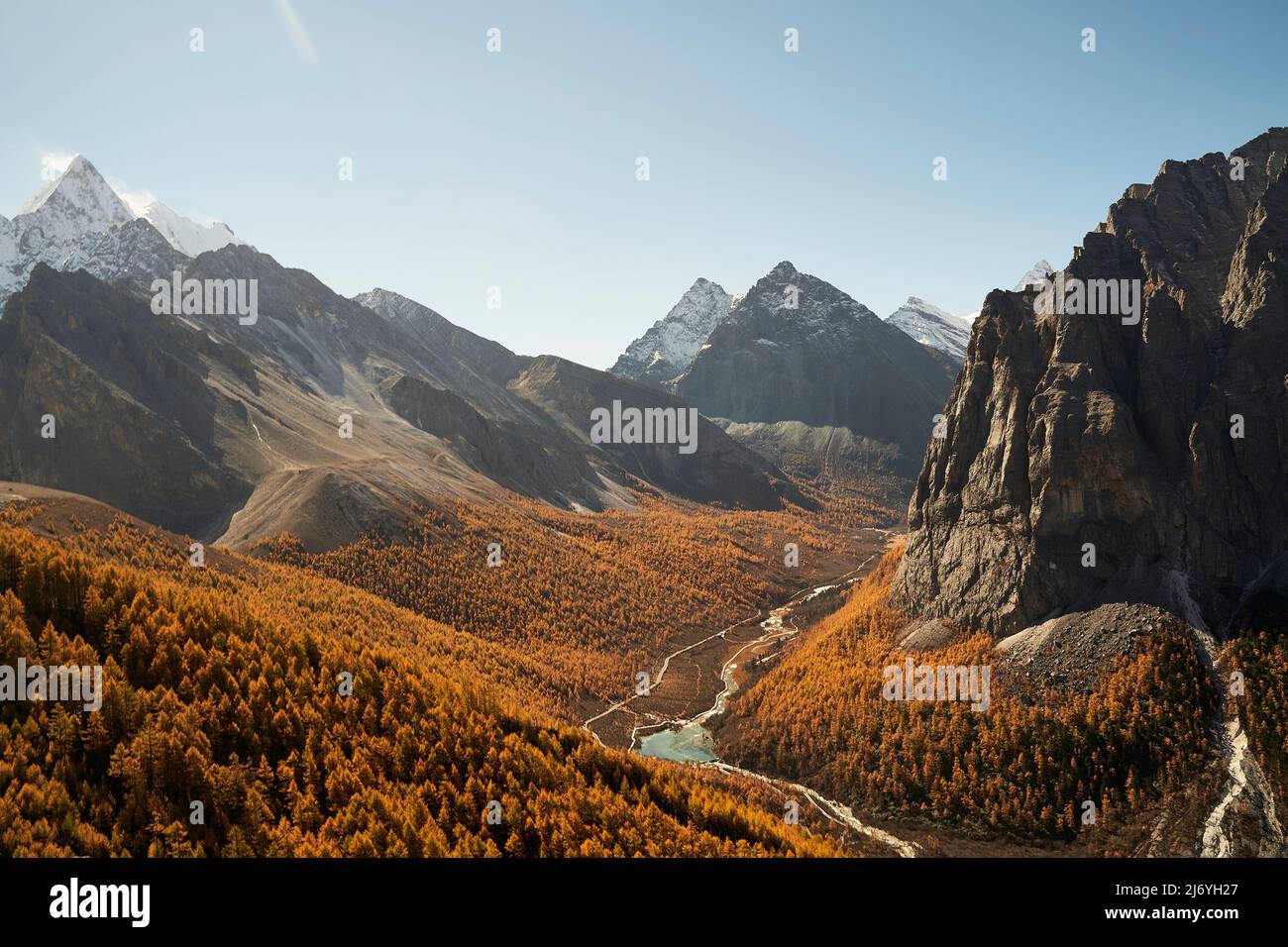 une vallée fluviale avec feuillage d'automne traversant les montagnes dans le parc national de yading, comté de daocheng, province du sichuan, chine Banque D'Images