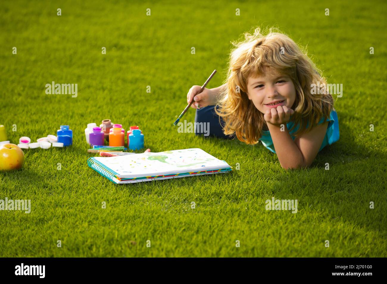 Les enfants créent artiste peint créativité vacances. Portrait d'un joyeux gamin souriant qui apprécie l'art et le dessin d'artisanat dans l'arrière-cour ou le parc de printemps. Enfants Banque D'Images