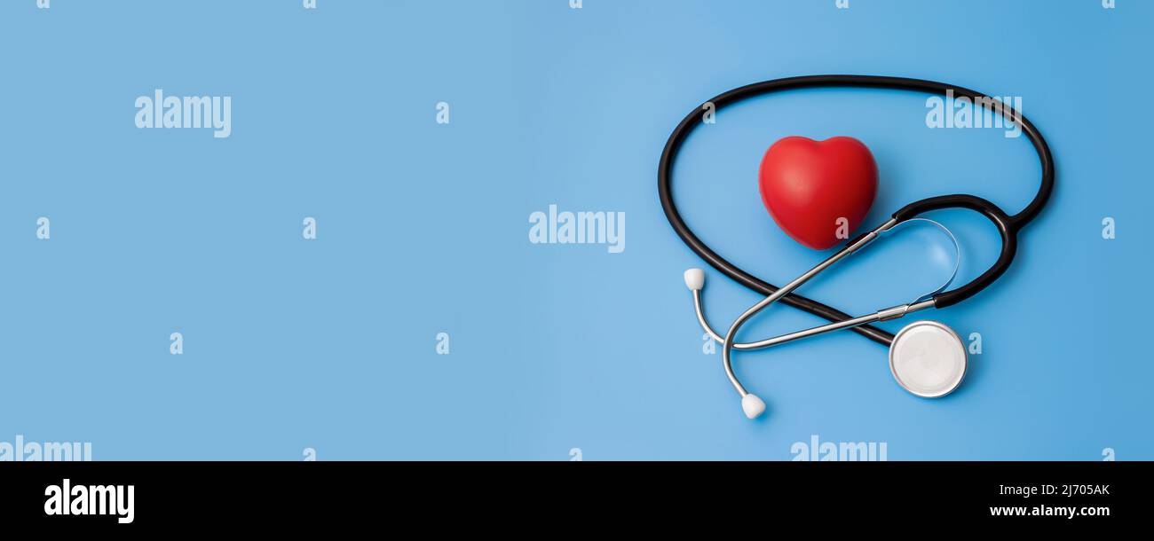 Stéthoscope et coeurs rouges sur fond bleu concept de soins de santé. Banque D'Images