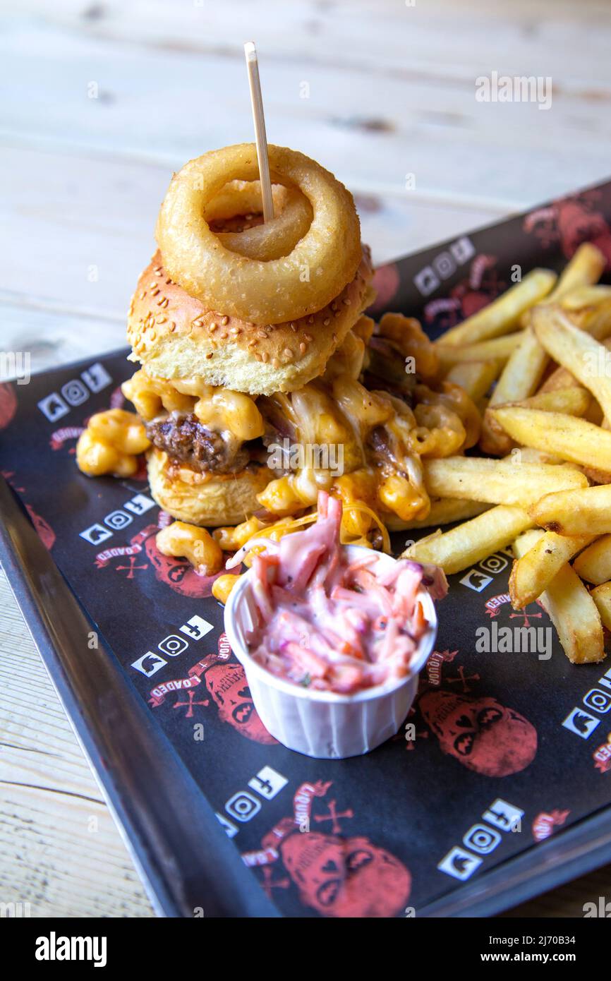 Mac Attack Burger recouvert de mac et de fromage avec frites à Liquor & Loaded, King's Lynn, Norfolk, Royaume-Uni Banque D'Images