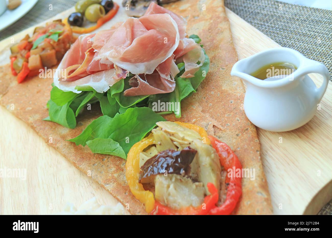 Crêpe Antipasto ou hors-d'œuvre crêpe à la charcuterie et variété de légumes sautés servis avec de l'huile d'olive Banque D'Images