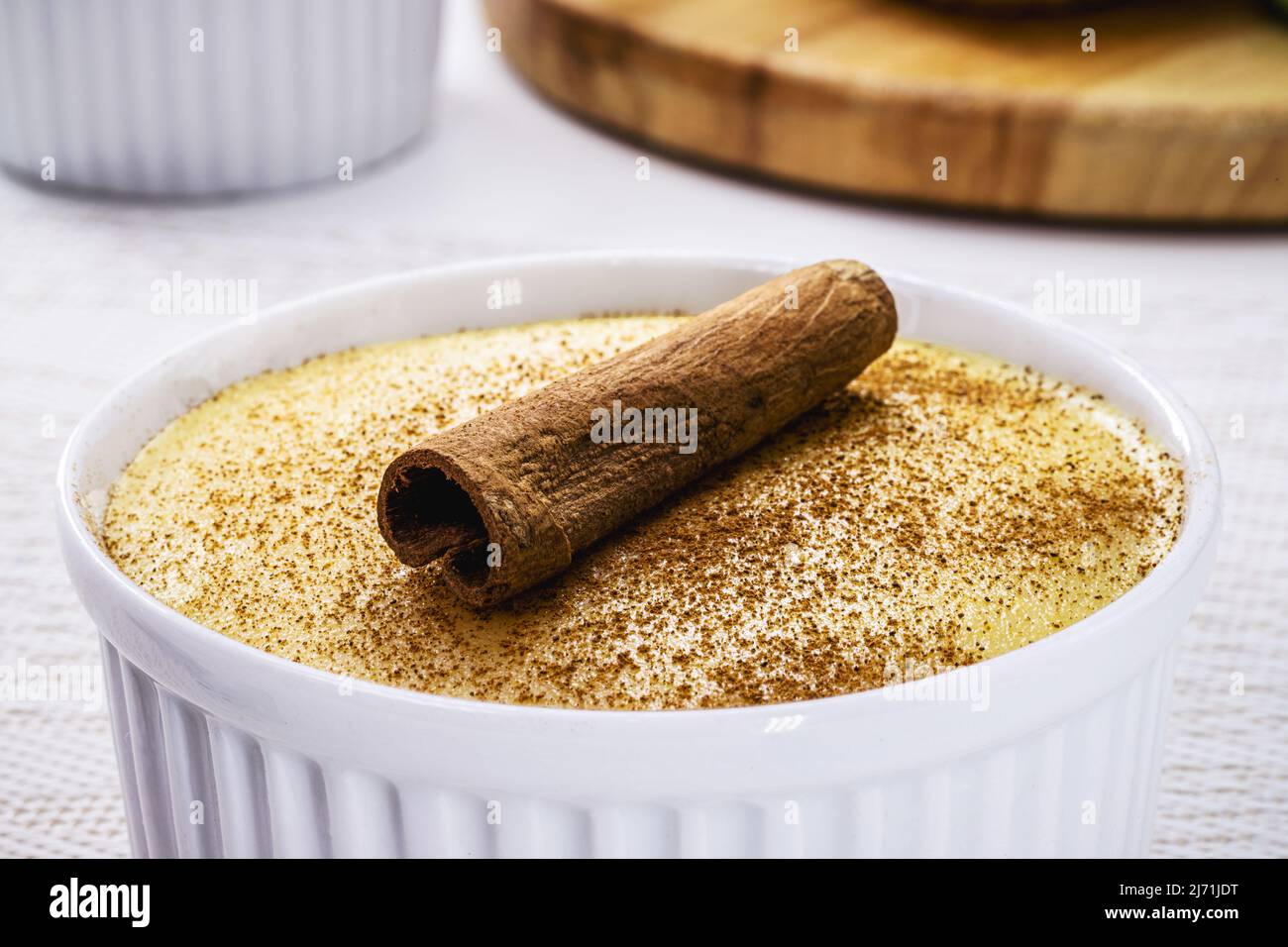 Le maïs sucré brésilien, appelé Curau, jimbelê ou canjica est une spécialité typique de la cuisine brésilienne. Décoration avec poudre de cannelle et bâton. Banque D'Images