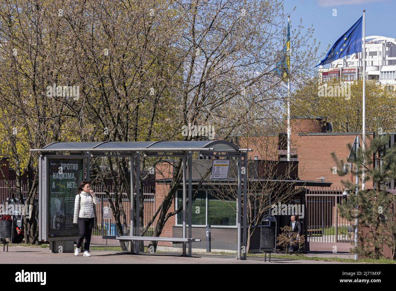 Une femme se tient à un arrêt de bus à côté d'une affiche avec un portrait du roi Gustaf V de Suède et le message "nous sommes contre le nazisme, ils ne sont pas", près de l'ambassade de Suède à Moscou, Russie le 5 mai 2022. PHOTOGRAPHE REUTERS/REUTERS Banque D'Images