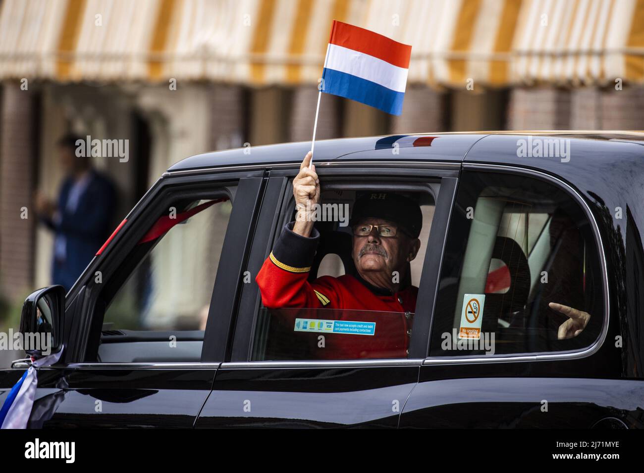 2022-05-05 12:48:41 WAGENINGEN - image atmosphérique d'un ancien combattant britannique de WW2 agitant un drapeau hollandais d'un taxi de Londres pendant le défilé annuel de libération à Wageningen comme un hommage aux libérateurs. Le jour de la libération a été célébré comme d'habitude après deux années de corona. ANP VINCENT JANNINK pays-bas sortie - belgique sortie Banque D'Images