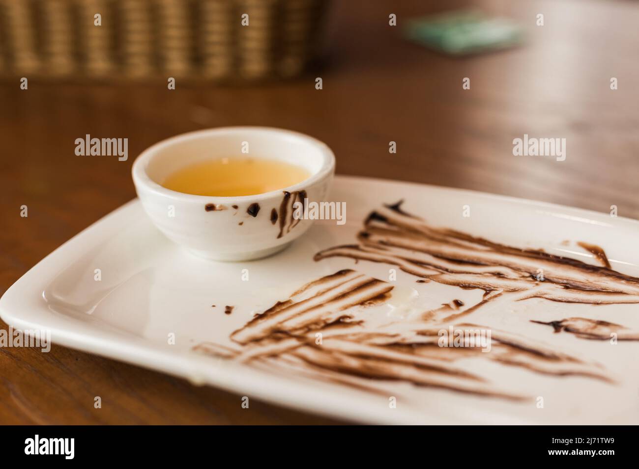 Gros plan de la cuillère sale après avoir mangé un gâteau au chocolat sur une assiette blanche dans le café Banque D'Images
