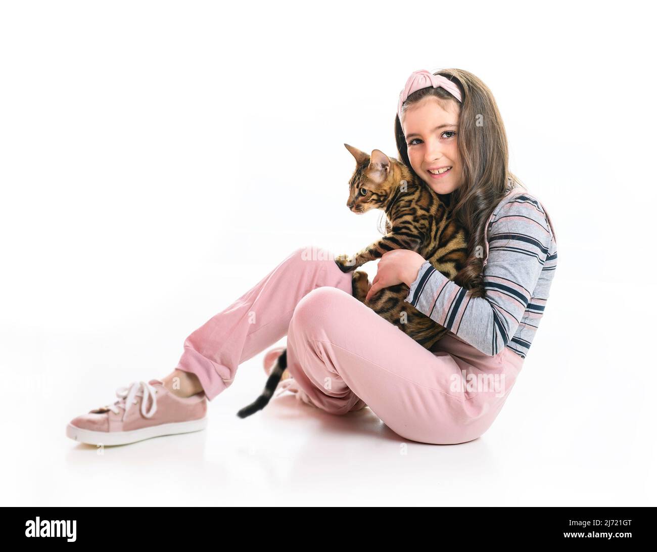 petite fille tenant chat bengale isolé sur fond blanc Banque D'Images