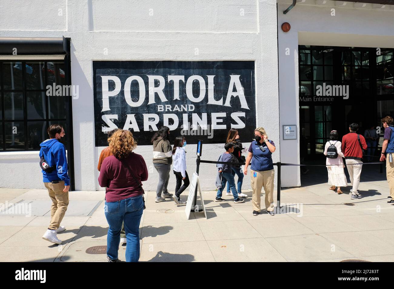 Panneau de la marque Portola Sardes à l'entrée de l'aquarium de la baie de Monterey à Monterey, Californie, États-Unis ; les clients entrent dans le bâtiment. Banque D'Images