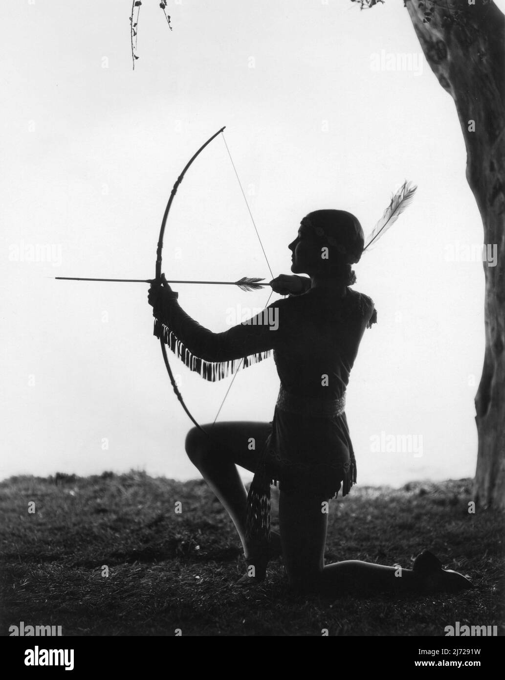 JEAN PARKER 1933 Leggy pose comme Native American Indian Girl avec Bow et Arrow par CLARENCE SINCLAIR BULL publicité pour Metro Goldwyn Mayer Banque D'Images