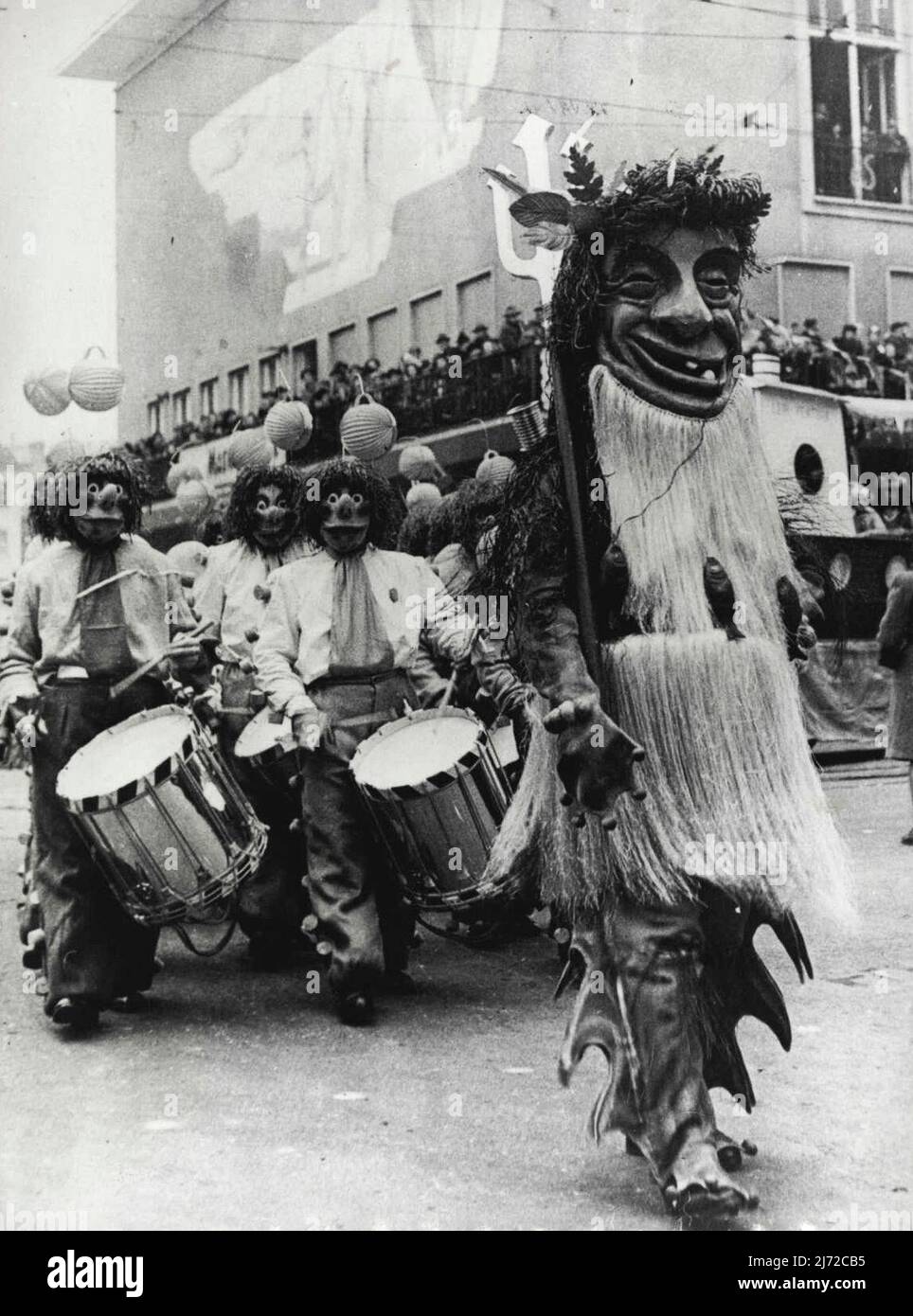 Le Carnaval de Drum à Bâle -- l'énorme figure fatiguée du Drum Major conduit un des Clubs de Drum pendant la procession de Carnaval à travers les rues de Bâle. Une caractéristique du Carnaval annuel de Bâle Suisse, est le défilé des Drummers. La mode Baslese du tambour est unique dans le monde entier et il y a environ trente clubs où cet curieux «art» est enseigné toute l'année. Toutes les pratiques sont effectuées sur les feutres jusqu'à ***** le bruit mais pendant un mois avant le carnaval, toutes les restrictions sont supprimées et les batteurs se laissaient vraiment aller. 24 janvier 1950. Banque D'Images