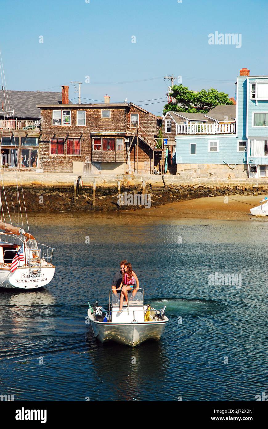 Un père et une fille sortent du port sur un petit bateau lors d'une journée d'été calme à Rockport, Massachusetts Banque D'Images