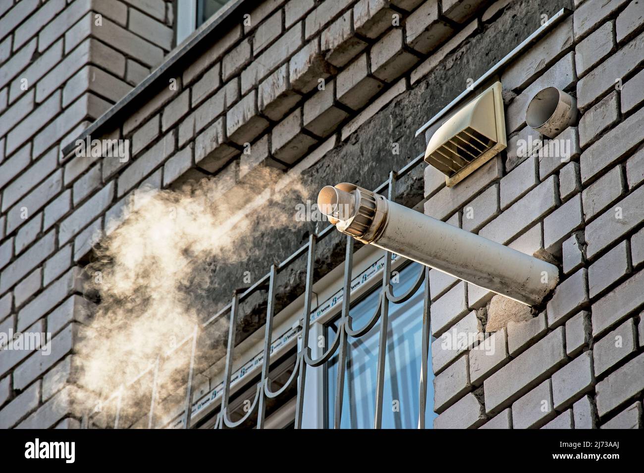 Extraction forcée de fumée d'une chaudière à combustible solide d'un appartement résidentiel à l'aide d'un système d'évacuation de fumée Banque D'Images