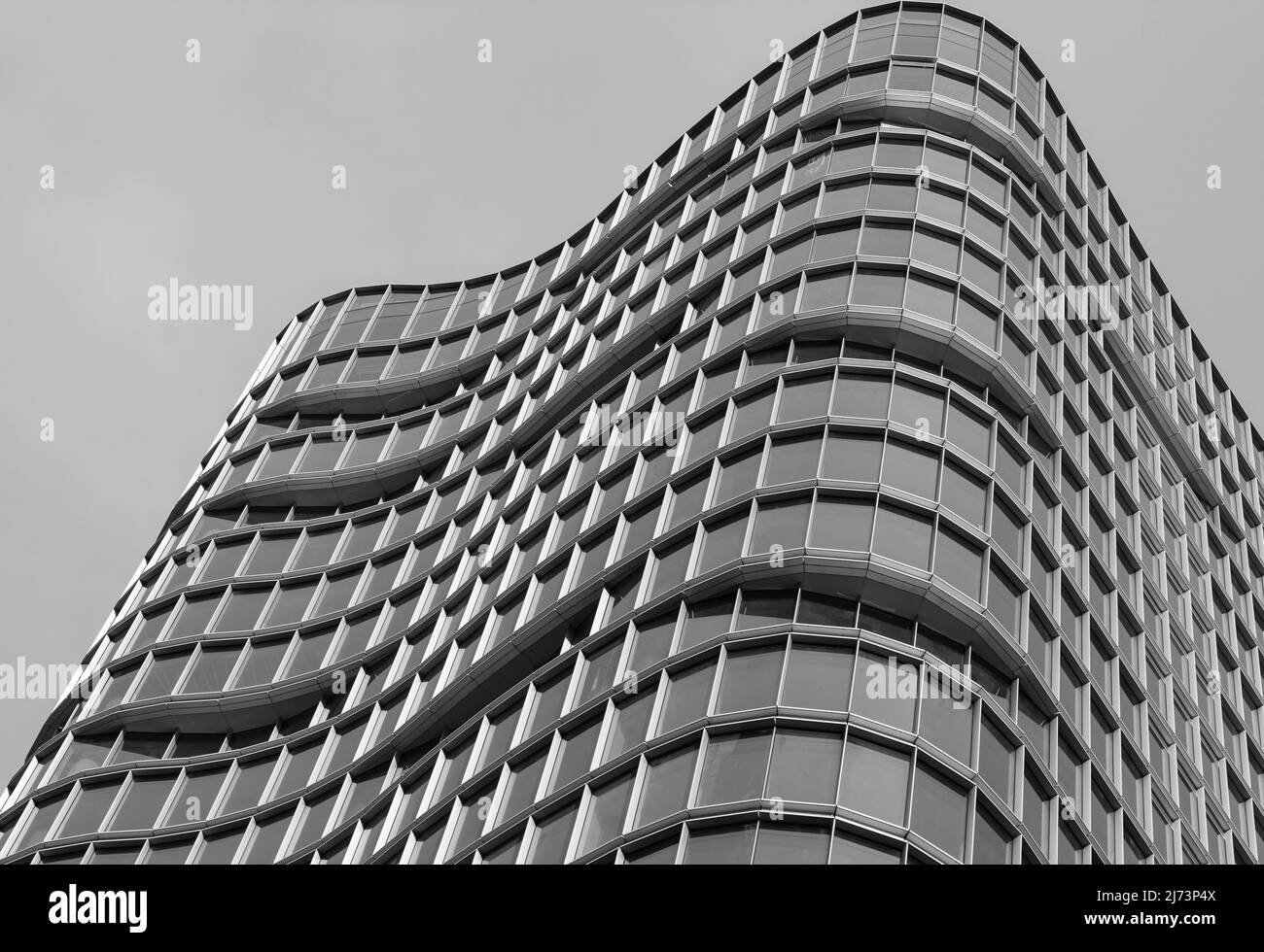 Architecture façade extérieure vue sur un mur de bâtiment moderne avec lumières et ombres. L'architecture urbaine moderne est un bâtiment en forme de vagues, un arrière-plan abstrait Banque D'Images