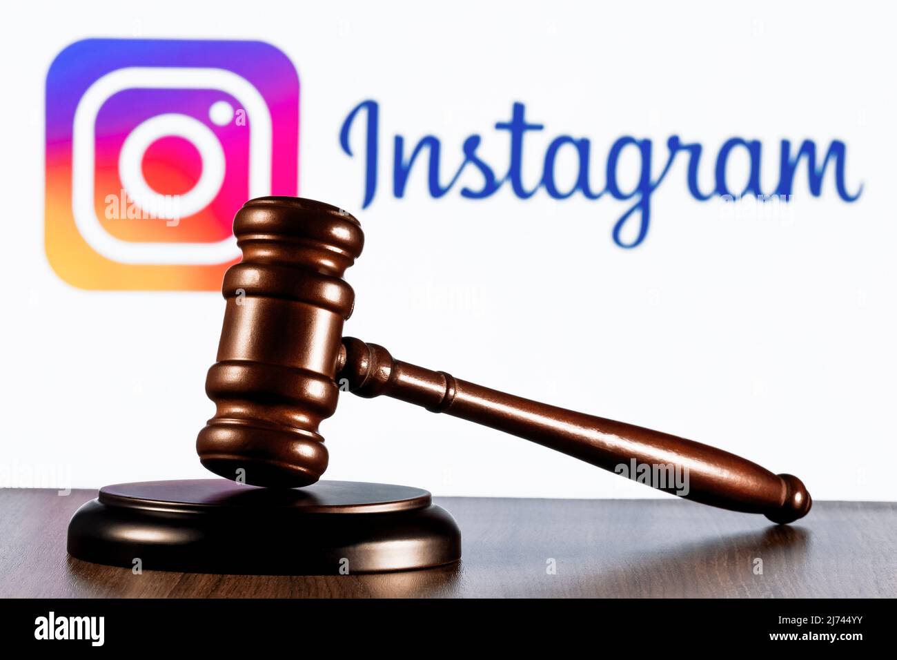 Gavel sur la table contre le fond du logo du réseau social Instagram. Le concept de procès. Banque D'Images