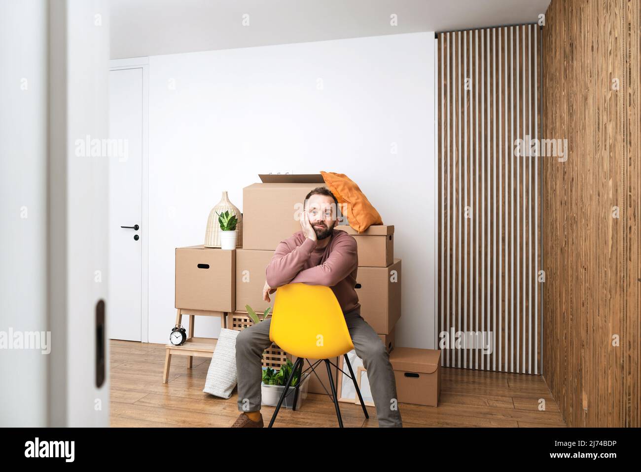 Homme mature se relaxant dans un nouvel appartement non meublé. Banque D'Images