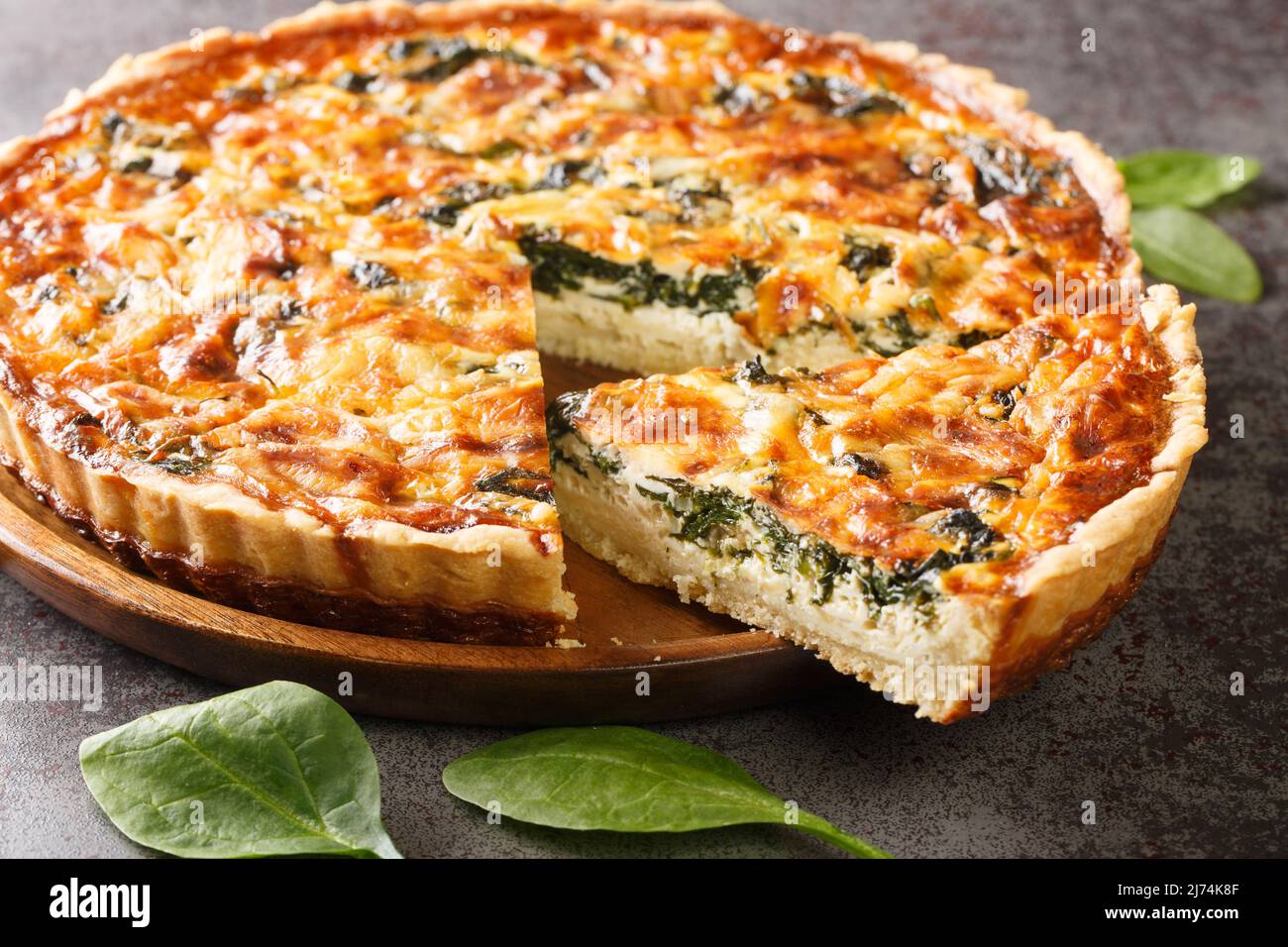 La quiche florentine est une quiche d'épinards frais cuite dans une croûte de tarte maison pour servir pour le brunch ou le petit déjeuner pour le dîner sur table grise gros plan. Hetizont Banque D'Images