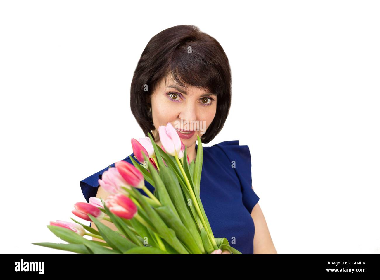 Portrait d'une femme heureuse de 35-40 ans avec un grand bouquet de tulipes parfumées sur fond blanc. Banque D'Images