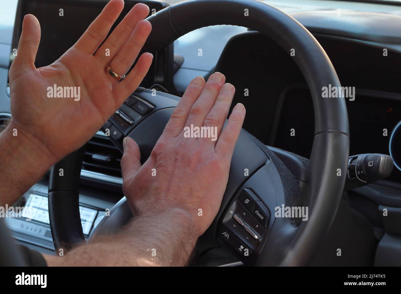 Gros plan des mains du conducteur en roquant l'avertisseur sonore Banque D'Images