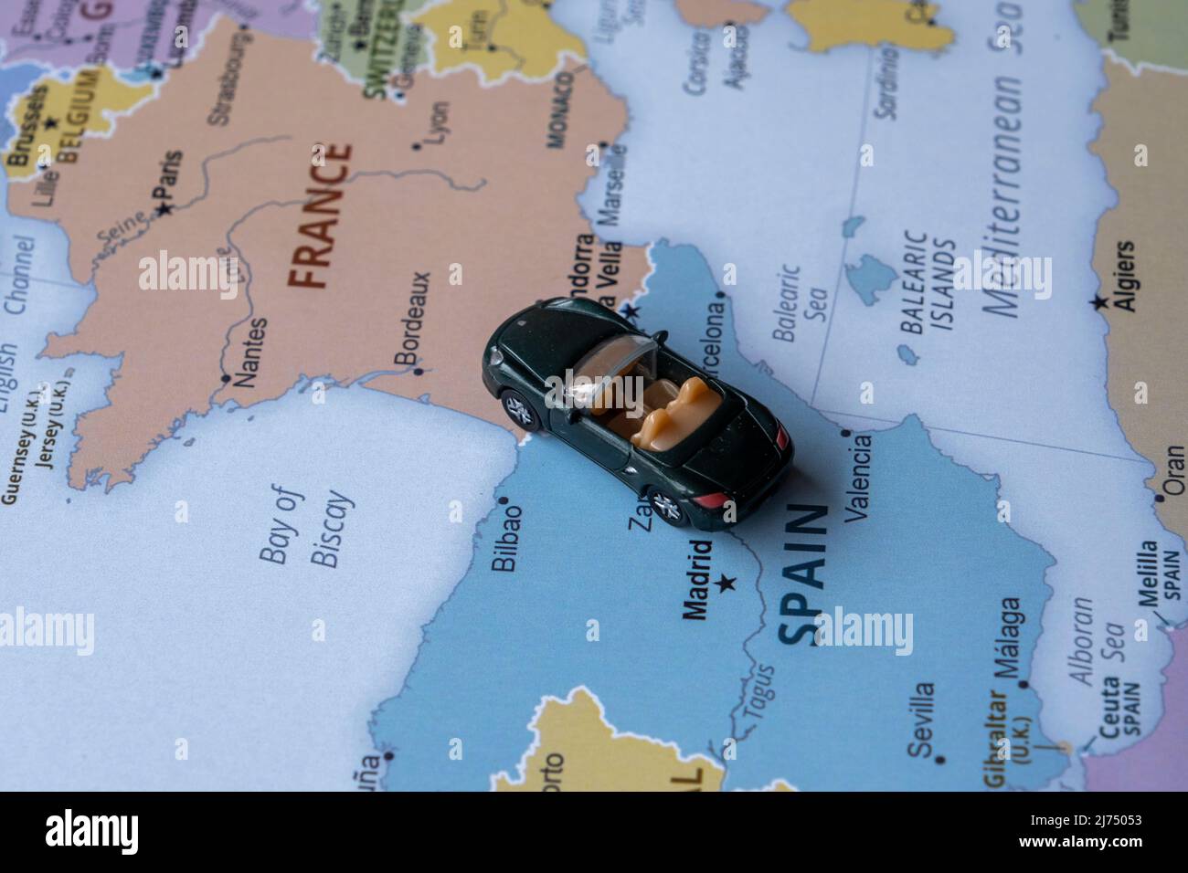 Voiture de jouet voyage sur la carte de l'Europe, vue assise, concept de  vacances et de destination, voiture de sport miniature verte aller en  France depuis l'Espagne, tour du monde Photo Stock -