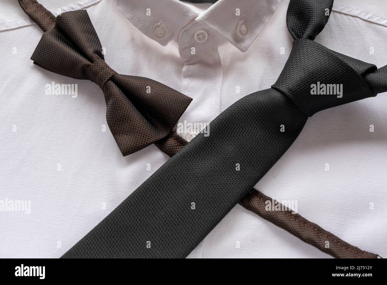 Cravate noire et noeud papillon sur chemise blanche, concept de mode hommes, accessoires de couleur noire, idée de vêtements hommes, vue assise Banque D'Images